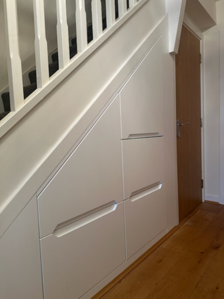 White handleless under stairs storage in Tameside